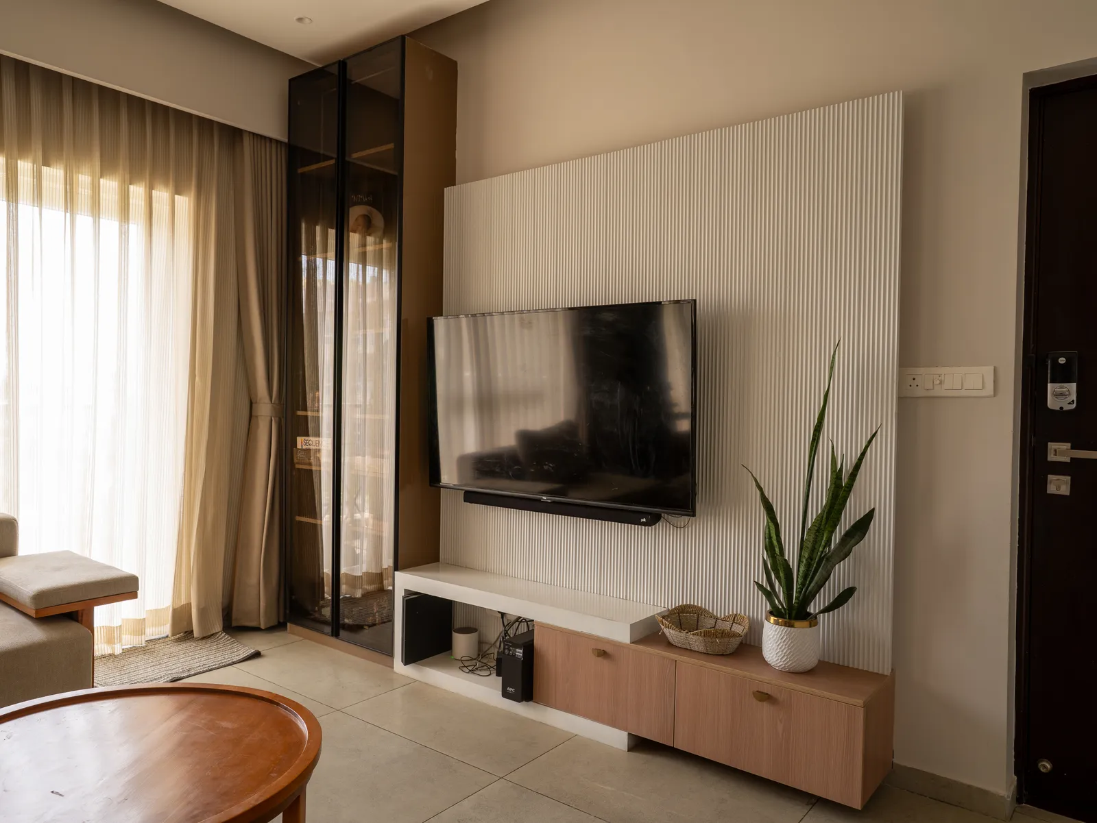 Living room with white fluted TV wall and oak console — Amlan's Residence